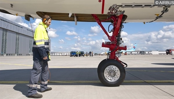 Nahaufnahme eines elektrisch angetriebenen Bugfahrwerks eines Verkehrsflugzeugs.