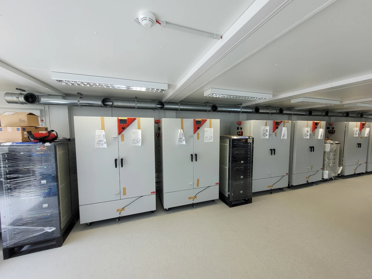 Ein Foto vom Inneren des Testlabors mit mehreren Klimakammern und Batterietestern.